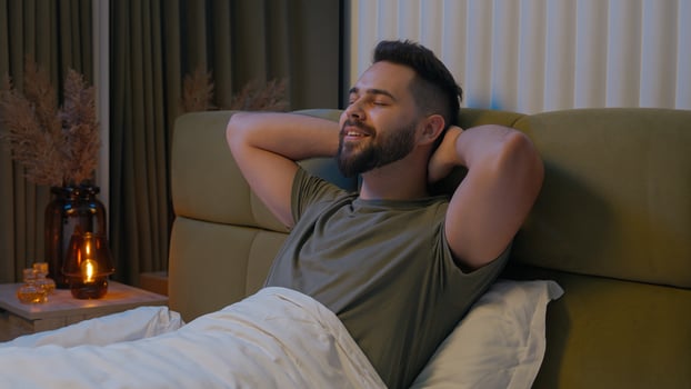 Happy Caucasian man prepare ready bed bedroom male relax cozy comfortable bedtime rest smiling pleasure apartment tenant duvet glad homeowner domestic enjoying hands behind head guy satisfaction sleep photo