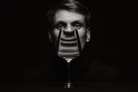 portrait of a man looking through a glass of water on a dark background photo