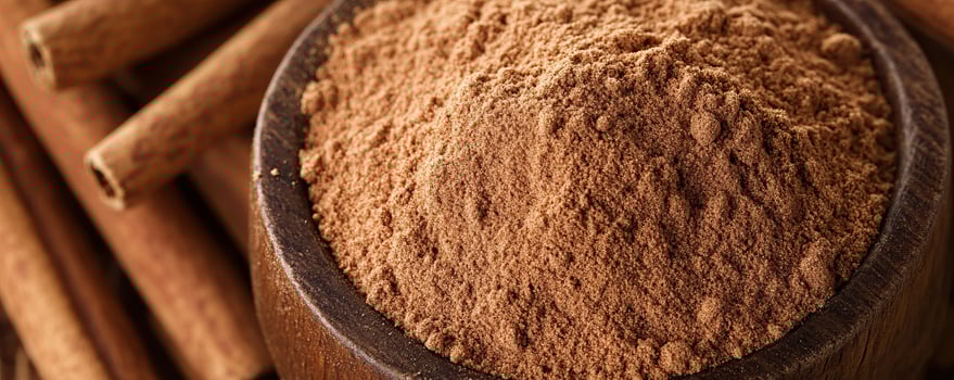 Ground cinnamon powder in a wooden bowl with cinnamon sticks, ideal for culinary and baking themes. photo