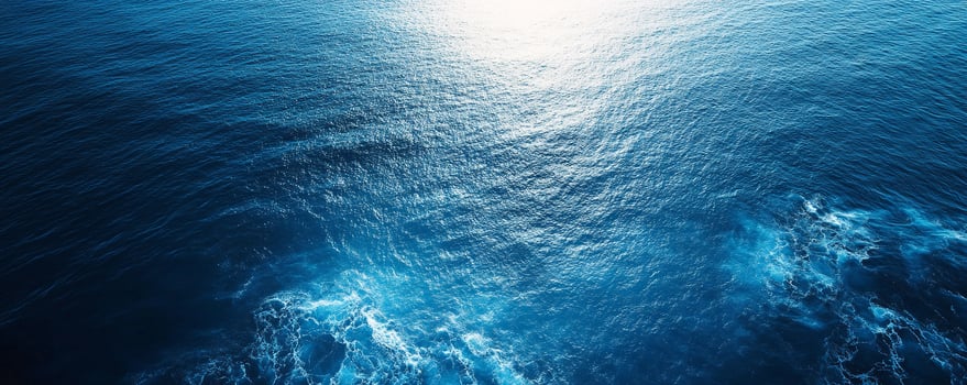 An aerial view of the ocean with sunlight shining through photo