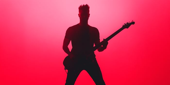 A silhouette of a man playing an electric guitar photo