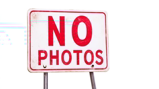 A no photos sign on a pole