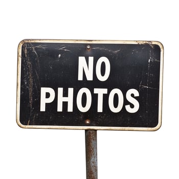 A no photos sign on a metal pole