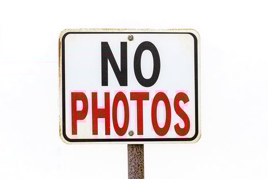 A no photos sign on a pole