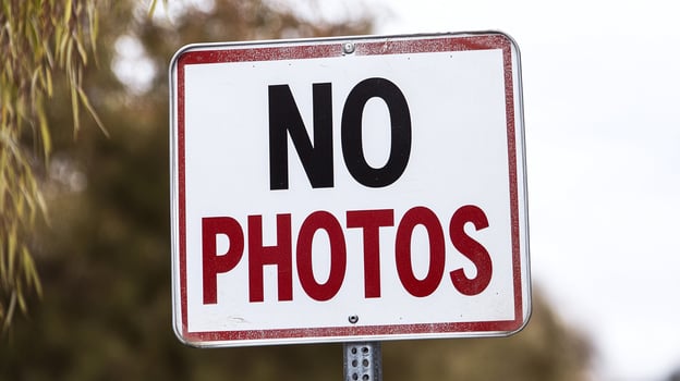 A no photos sign on a pole