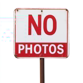A red and white sign with the words no photos