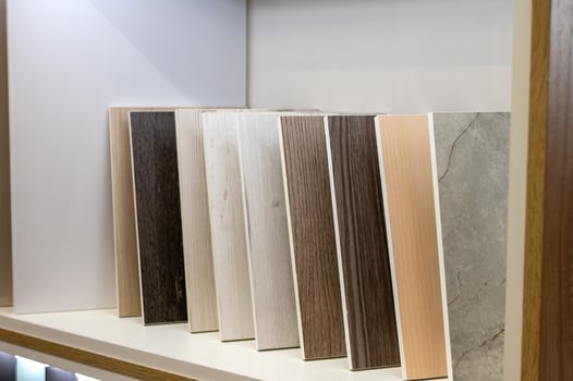 Wooden and stone flooring samples displayed on a shelf. photo