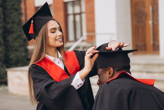 Joyful Graduates Celebrating Academic Achievement in Traditional Caps and Gowns Outside a University Building photo