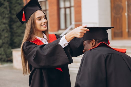 Joyful Graduates Celebrating Academic Achievement in Traditional Caps and Gowns Outside a University Building photo