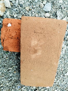 Rough Clay Bricks Over Gravel Background, Highlighting Construction Elements photo