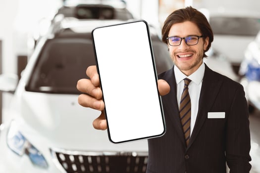 Salesperson In Specs Showing Auto Key To Camera Standing In Automobile Rental Office. Copyspace, Selective Focus photo