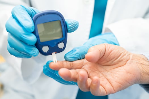 Doctor check diabetes from finger blood sugar level with finger lancet. photo