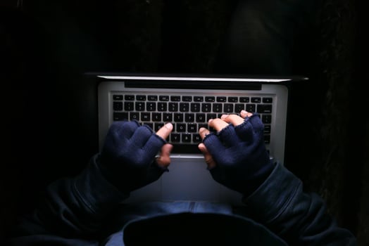 hacker hand stealing data from laptop top down photo