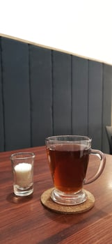 Hot tea in glass cup with sugar on table photo