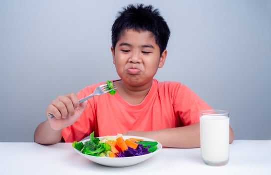Children do not like to eat vegetables, Little cute boy refuses to eat healthy vegetables, Nutrition healthy eating habits for kids concept, Children do not like to eat vegetables. photo