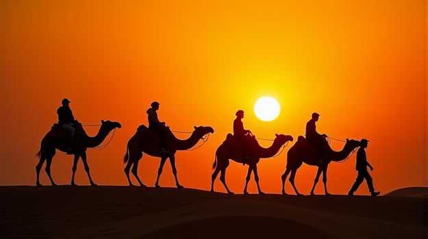 Silhouette of Camel Riders Against an Orange Hued Sky on a Desert Dunes Under Dramatic Sunset photo