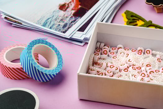 Crafting supplies for scrapbooking arranged on a purple surface photo