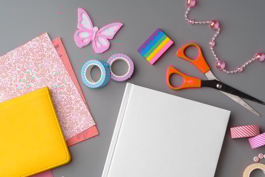 Crafting supplies arranged for a DIY project on a gray table with scissors, washi tape, and decorative items photo