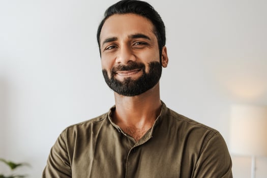 Confident, smiling indian male entrepreneur looking at camera standing on white background photo