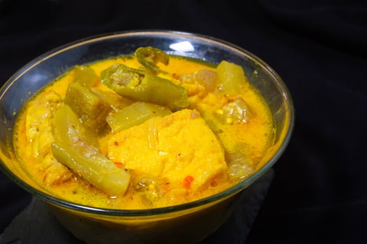 lodeh in a bowl on a black background. Sayur lodeh is a typical Indonesian vegetable dish made from coconut milk. photo
