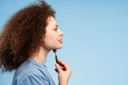 Side view, attractive woman with curly hair, looking in mirror, doing roller massage, lifting photo