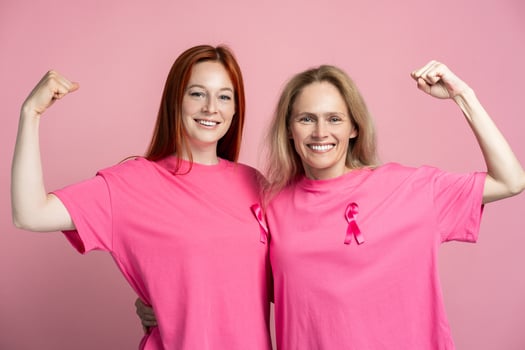 Women showing biceps on hands wearing pink t shirts with pink ribbons for breast cancer awareness photo