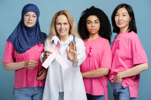 Doctor and women united against breast cancer with pink ribbon showing stop sign looking at camera photo
