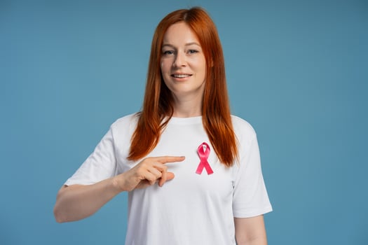 Woman pointing at pink ribbon supporting breast cancer awareness photo