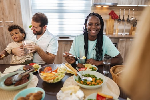 Family sharing a joyful meal in a cozy kitchen photo