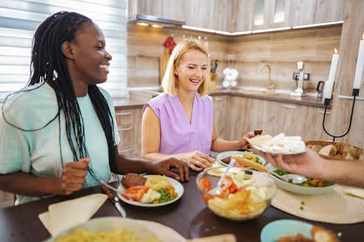 Friends share a delightful meal in a cozy kitchen setting photo