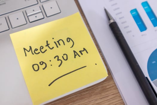 Yellow sticky note with the word Meeting 09.30 AM on a laptop. Meeting schedule concept. photo