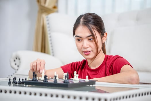Portrait of Woman moving chess, Asian woman plays chess in living room photo
