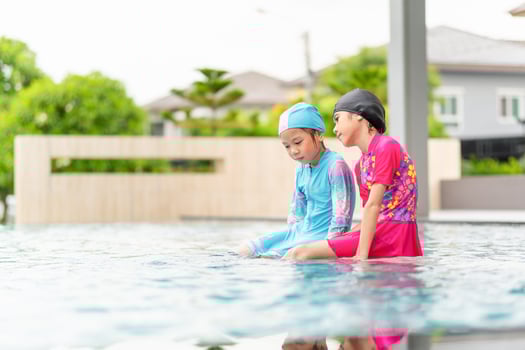 Asian children in swimsuit playing in swimming pool, Asian kids girl playing and having fun in swimming pool photo