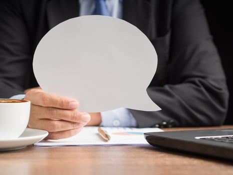Hand holding of an empty white speech bubble photo