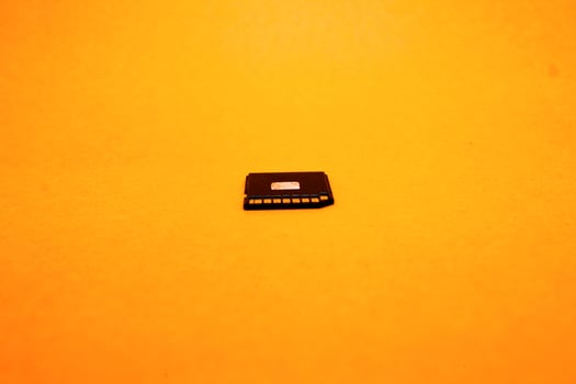 Black SD memory card isolated on yellow background photo