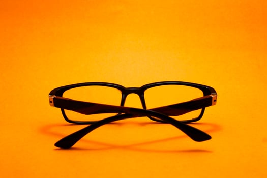 a pair of glasses isolated on yellow background photo