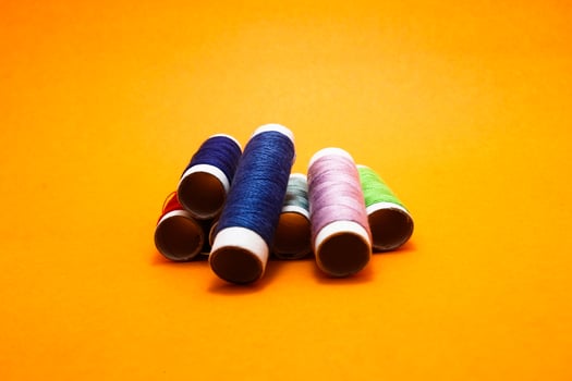 sewing thread roll isolated on yellow background photo