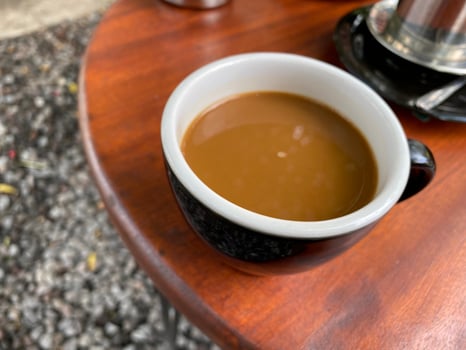 coffee with milk in a black glass, served on the table photo