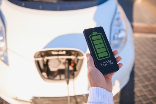 Man charges an electric car at the charging station photo