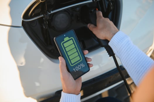 Smartphone app shows charging status of the electric car battery. Electro transport concept photo