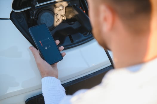 Man charges an electric car at the charging station photo