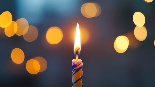 A Single Birthday Candle Burning Brightly Against a Blurred Background of Lights photo