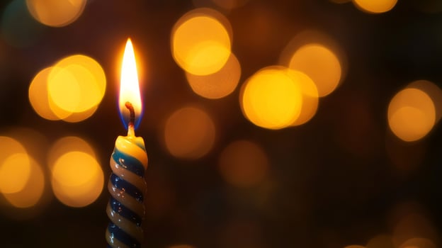 A Single Birthday Candle with a Blurred Background of Yellow Lights photo