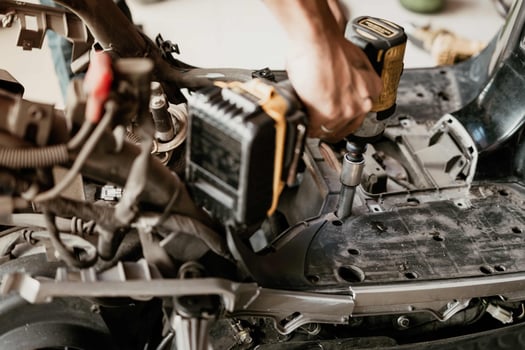 Motorcycle mechanic use Cordless Impact Driver to repair motorcycle in garage, photo