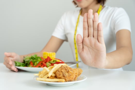 Beauty slim female body confuse French fries and fried chicken. Woman in restaurant achieves weight loss goal for healthy life, crazy about thinness, thin waist, nutritionist. Diet, body shape. photo