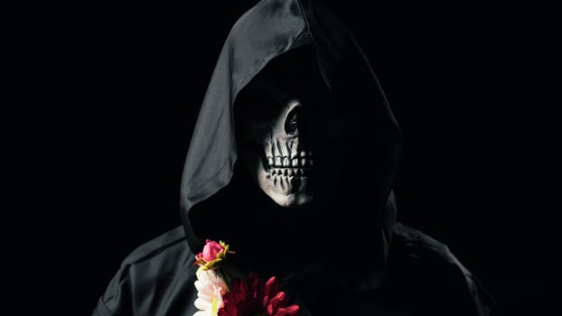 Dead man mask holding the flowers photo