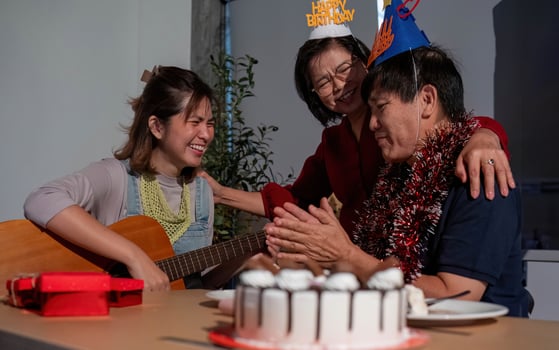 A man and two women are celebrating a birthday photo