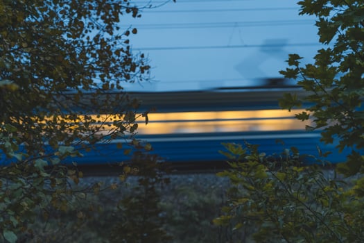 The electric train goes fast in the evening. Long exposure, lubrication photo