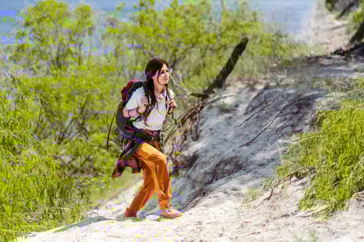 Hiking, smile and woods with woman walking in nature or the wilderness for adventure photo