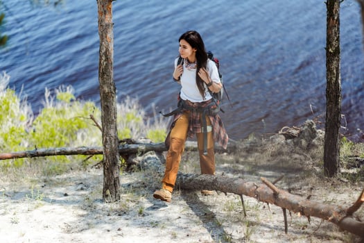 Hiking, smile and woods with woman walking in nature or the wilderness for adventure photo